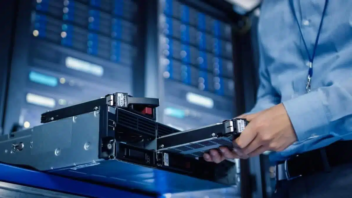 close up image of a man removing the harddrive from a server rack